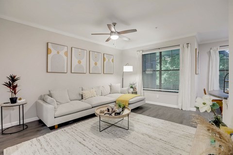a living room with a white couch and a ceiling fan